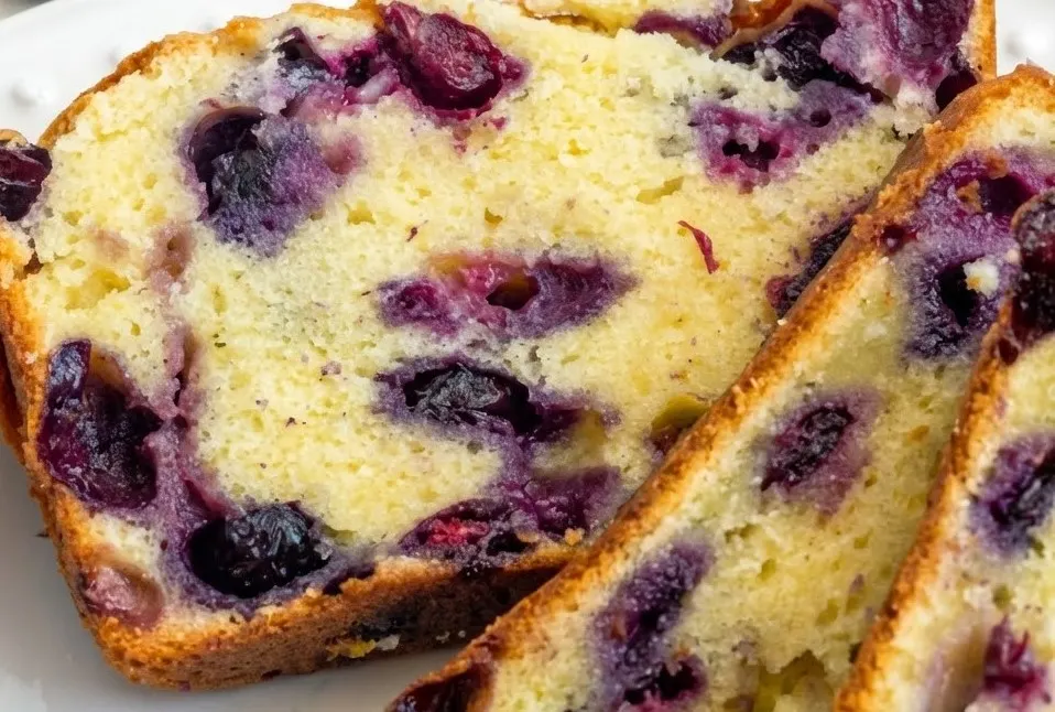 Sliced blueberry cream cheese loaf showing moist crumb and creamy blueberry pockets