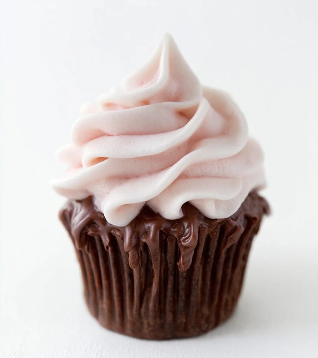 Chocolate cupcake topped with fluffy strawberry marshmallow frosting swirl