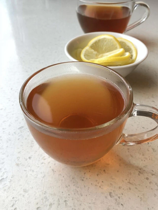 Gelatin trick recipe drink made with tea served in a clear glass cup with lemon slices