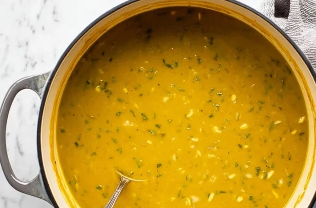 Vegan curry lentil soup simmering in a pot on the stove
