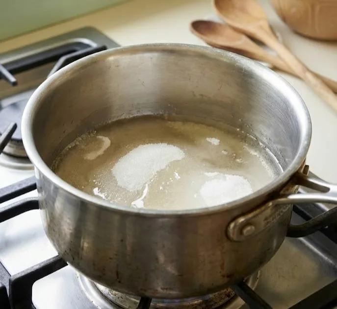 Sugar and corn syrup heating in saucepan on stovetop for homemade marshmallows